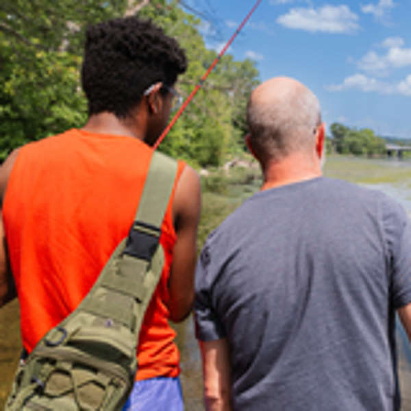 Foster dad and foster child fishing on a sunny day.